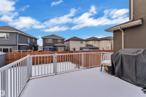 The property features a spacious deck with white railings and a gate, overlooking a fenced yard - 2630 16A Ave Nw, Edmonton, AB - Outdoor With Deck Patio Veranda With Exterior