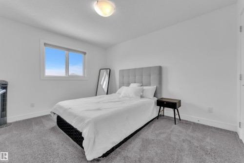 This room features a window providing natural light, white walls, and gray carpeting - 2630 16A Ave Nw, Edmonton, AB - Indoor Photo Showing Bedroom