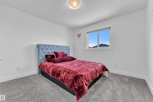 This room features light gray carpeting, white walls, and a window providing natural light - 2630 16A Ave Nw, Edmonton, AB - Indoor Photo Showing Bedroom