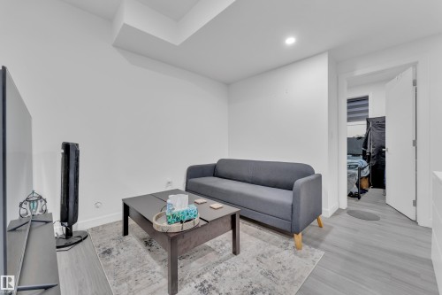 The property features bright white walls, recessed ceiling lighting, and light-toned flooring - 2630 16A Ave Nw, Edmonton, AB - Indoor Photo Showing Living Room