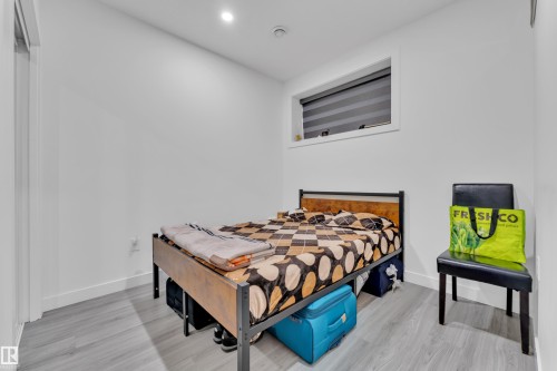 This room features light-colored flooring, white walls, and a window with blinds - 2630 16A Ave Nw, Edmonton, AB - Indoor Photo Showing Bedroom
