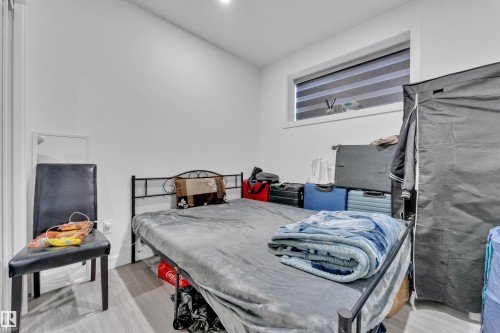 This room features a window with blinds, light-colored flooring, and white walls - 2630 16A Ave Nw, Edmonton, AB - Indoor Photo Showing Bedroom