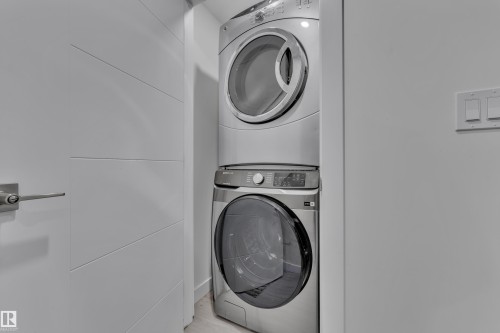Laundry area featuring a stacked washer and dryer unit - 2630 16A Ave Nw, Edmonton, AB - Indoor Photo Showing Laundry Room