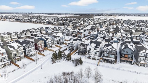 The property is in a residential area featuring a variety of architectural styles, surrounded by a snow-covered landscape - 3230 Parker Loop, Edmonton, AB - Outdoor With View