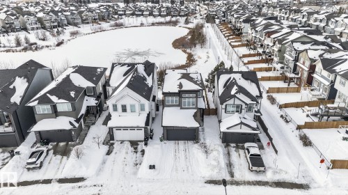 This property is situated in a neighbourhood with residential homes and a frozen body of water - 3230 Parker Loop, Edmonton, AB - Outdoor With Facade