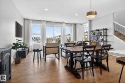 Open concept living and dining area featuring hardwood flooring, recessed lighting, and a modern light fixture above the dining table - 