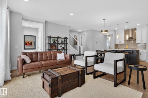 Open concept living area featuring light-toned flooring, recessed lighting, and a view of the kitchen with pendant lighting - 3230 Parker Loop, Edmonton, AB - Indoor