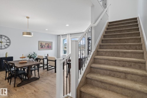 The property features a staircase with carpeted treads and a railing with dark metal spindles and a white banister - 3230 Parker Loop, Edmonton, AB - Indoor