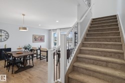 The property features a staircase with carpeted treads and a railing with dark metal spindles and a white banister - 