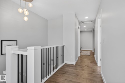 Hallway featuring light wood-style flooring, recessed lighting, and a modern chandelier - 3230 Parker Loop, Edmonton, AB - Indoor Photo Showing Other Room
