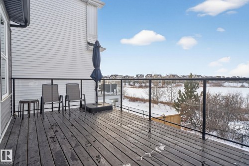 The property features an outdoor deck with dark wood planks and a glass panel railing - 3230 Parker Loop, Edmonton, AB - Outdoor