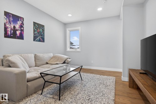 This property features light-colored walls, recessed lighting, and wood flooring - 3230 Parker Loop, Edmonton, AB - Indoor Photo Showing Living Room