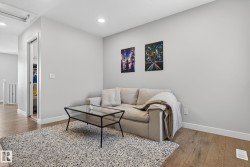 This inviting living area features hardwood flooring, a neutral color palette on the walls, and recessed lighting - 
