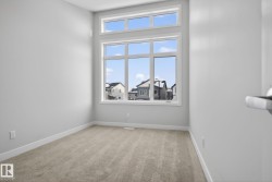 This room features light-colored carpet flooring and white painted walls, creating a bright and airy atmosphere - 