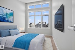 This bedroom features a large window with transom windows above, allowing natural light to fill the space - 