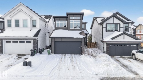 This property features a modern exterior with a dark grey facade, large windows, and an integrated garage - 3230 Parker Loop, Edmonton, AB - Outdoor With Facade