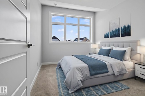 A bright and airy bedroom featuring a large window, plush carpet, and a modern paneled door - 3230 Parker Loop, Edmonton, AB - Indoor Photo Showing Bedroom
