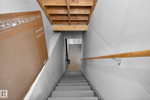 Staircase with a wooden handrail and light-colored steps - 3230 Parker Loop, Edmonton, AB - Indoor Photo Showing Other Room
