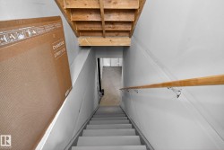 Staircase with a wooden handrail and light-colored steps - 