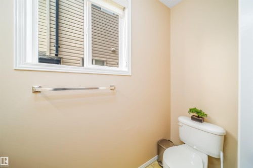 The property features a restroom with a window, a toilet, and light-toned walls - 8932 175 Avenue, Edmonton, AB - Indoor Photo Showing Bathroom