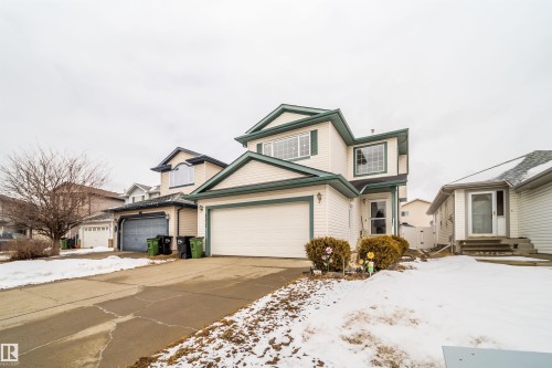 This property features light-colored siding with dark trim, a two-car garage, and an additional single-car garage - 8932 175 Avenue, Edmonton, AB - Outdoor With Facade