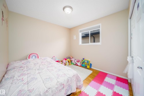 This room features neutral-toned walls, a window providing natural light, and hardwood flooring - 8932 175 Avenue, Edmonton, AB - Indoor Photo Showing Bedroom