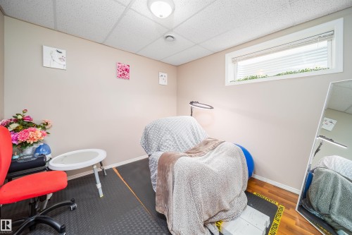 This room features a drop ceiling, a window with blinds providing natural light, and light-colored walls - 8932 175 Avenue, Edmonton, AB - Indoor