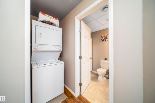 The property features a dedicated laundry area with a stacked washer and dryer, conveniently located near a bathroom with tiled flooring - 8932 175 Avenue, Edmonton, AB - Indoor Photo Showing Laundry Room