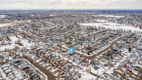 Aerial view of the surrounding residential neighborhood with snow-covered grounds and streets, featuring a nearby body of water - 8932 175 Avenue, Edmonton, AB - Outdoor With View