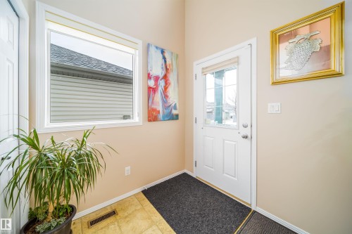 The property features a front door with a window inset, a large window, and light-colored walls - 8932 175 Avenue, Edmonton, AB - Indoor Photo Showing Other Room