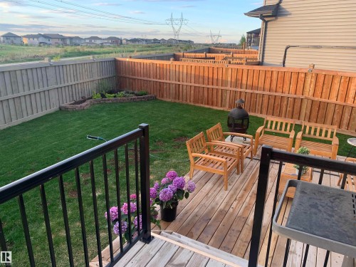 The property features a spacious backyard with a well-maintained lawn and a raised garden bed - 7490 Creighton Place, Edmonton, AB - Outdoor With Deck Patio Veranda