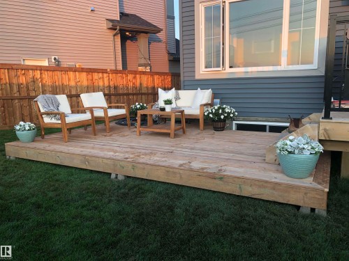 The property features a wooden deck with clear views of the rear of the home, which has horizontal siding and white-trimmed windows - 7490 Creighton Place, Edmonton, AB - Outdoor With Deck Patio Veranda With Exterior