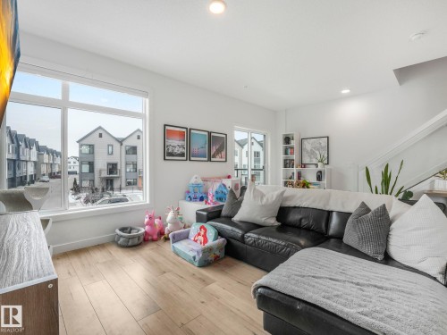 Living space featuring light-toned flooring, large windows, and white walls - 95 1010 Rabbit Hill Road, Edmonton, AB - Indoor Photo Showing Living Room
