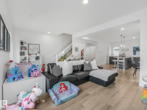 The property features an open concept living area with light wood flooring, recessed lighting, and white walls - 95 1010 Rabbit Hill Road, Edmonton, AB - Indoor Photo Showing Living Room