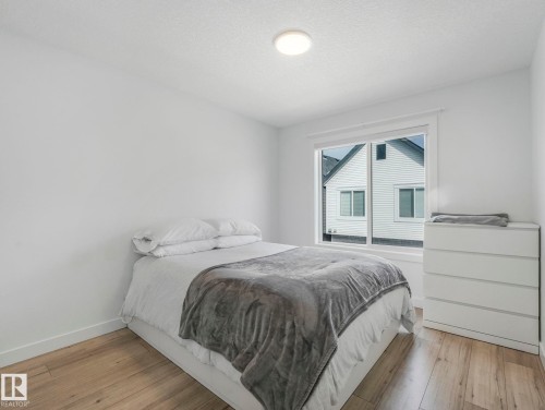Bedroom featuring light wood flooring, white walls, and a window providing natural light - 95 1010 Rabbit Hill Road, Edmonton, AB - Indoor Photo Showing Bedroom