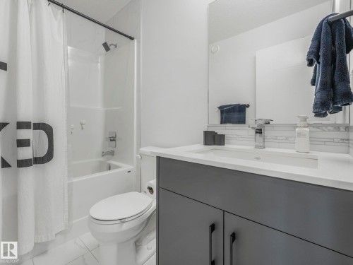 Bathroom featuring a modern vanity with a white countertop, a rectangular sink, and a large mirror - 95 1010 Rabbit Hill Road, Edmonton, AB - Indoor Photo Showing Bathroom