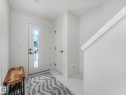 Inviting entryway featuring a white front door with a vertical window pane, tiled flooring, and a white staircase with a prominent handrail - 95 1010 Rabbit Hill Road, Edmonton, AB  - Indoor Photo Showing Other Room 