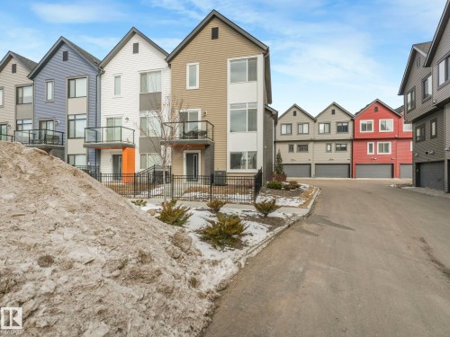 The property features a modern exterior with a light brown facade and an attached balcony with a glass railing - 95 1010 Rabbit Hill Road, Edmonton, AB - Outdoor With Facade