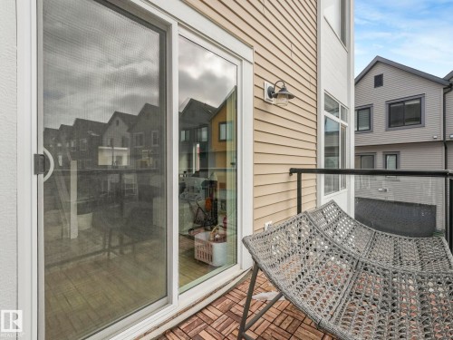 The property features a balcony with a tiled surface, a glass railing, and a wall-mounted light fixture - 95 1010 Rabbit Hill Road, Edmonton, AB - Outdoor