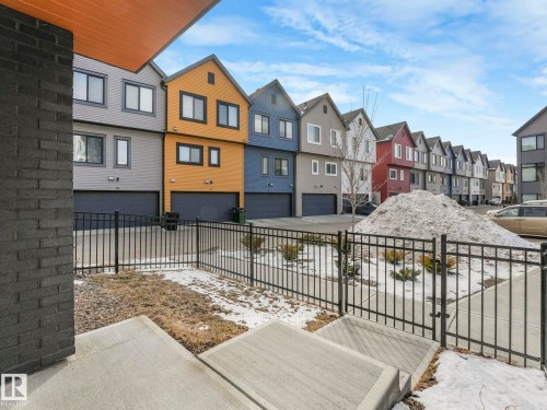 The property features a modern exterior with a black brick facade and a contrasting wood soffit - 95 1010 Rabbit Hill Road, Edmonton, AB - Outdoor