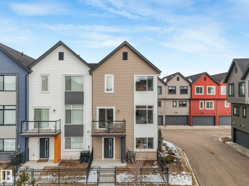 This property features a modern exterior with a mix of siding types and colors, including white, tan, and blue - 95 1010 Rabbit Hill Road, Edmonton, AB - Outdoor With Facade