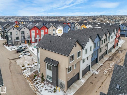 This property is a multi-story home featuring light-colored siding, a dark roof, and a visible garage door - 95 1010 Rabbit Hill Road, Edmonton, AB - Outdoor