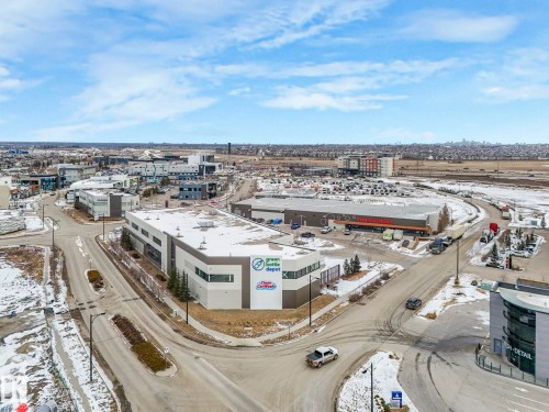 The commercial property features a large building with a modern facade and extensive parking - 95 1010 Rabbit Hill Road, Edmonton, AB - Outdoor With View