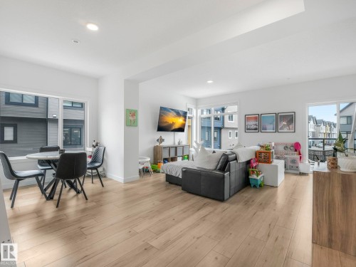 Open concept living space featuring light-toned flooring, recessed lighting, and large windows that provide views of the surrounding properties - 95 1010 Rabbit Hill Road, Edmonton, AB - Indoor Photo Showing Living Room