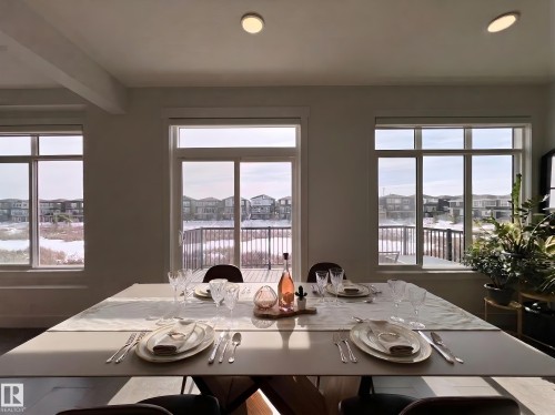 The dining area features large windows and a sliding glass door providing natural light - 6055 King Landing Landing, Edmonton, AB - Indoor Photo Showing Dining Room