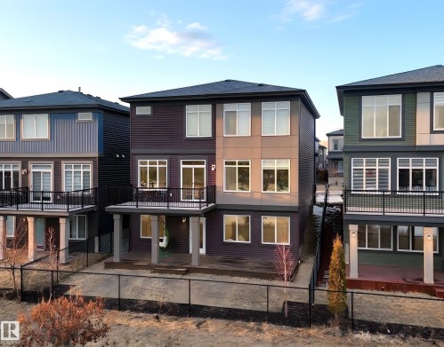 The property features a dark-colored exterior with lighter accent panels, white-framed windows, and a dark roof - 6055 King Landing Landing, Edmonton, AB - Outdoor With Facade