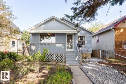 The property features light blue siding, a covered front porch with a railing, and steps leading to the front door - 