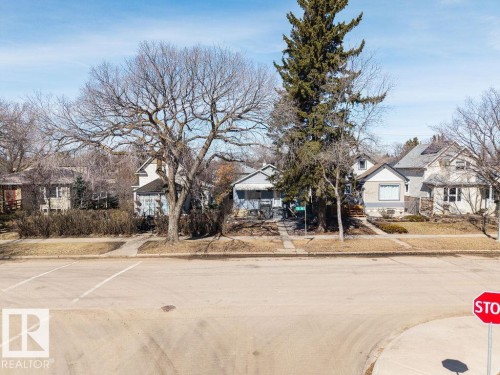 The property is located on a paved street with a sidewalk and features mature trees within its front yard - 8736 76 Avenue, Edmonton, AB - Outdoor