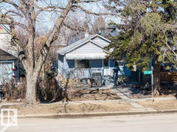 The property features light blue siding, a front porch with white railings, and a blue and white striped awning over the porch - 