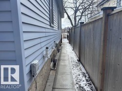 This property features a well-maintained exterior with light blue horizontal siding and a visible foundation. NEW Drainage/Slope away from structure and sidewalks laid down . - 